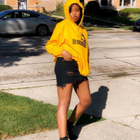 Load image into Gallery viewer, model wearing chicago bronzeville hoodie chicago hoodies unisex chicago neighborhood historic bronzeville chicago black renaissance legacy collection side view gold hoodie black letters